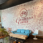 Light blue couch in front of decorated wall that says Carabello Coffee