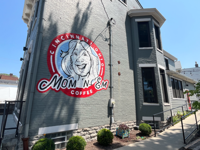 The Mom 'N 'Em face logo on the exterior wall of the Camp Washington location