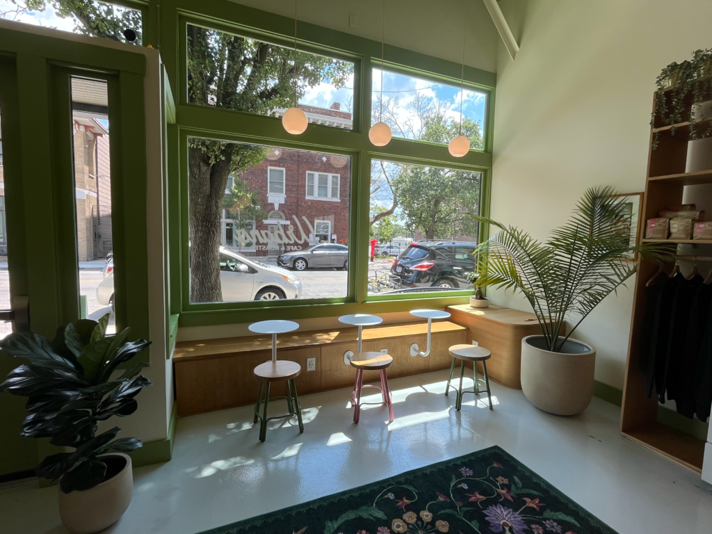 Light shining through the window onto three circular tables inside Urbana Cafe
