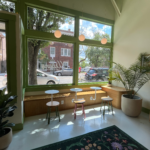 Light shining through the window onto three circular tables inside Urbana Cafe