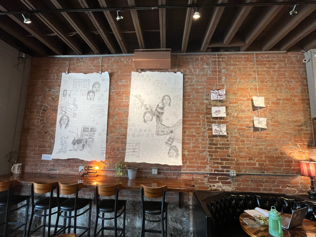 Large drawings on white canvases on a brick wall in the art gallery inside The 86 Coffee Bar