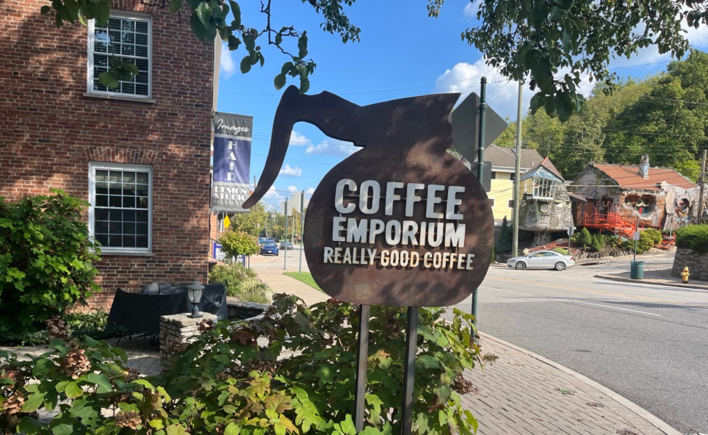 Outdoor sign shaped like a coffee pot that says "Coffee Emporium"